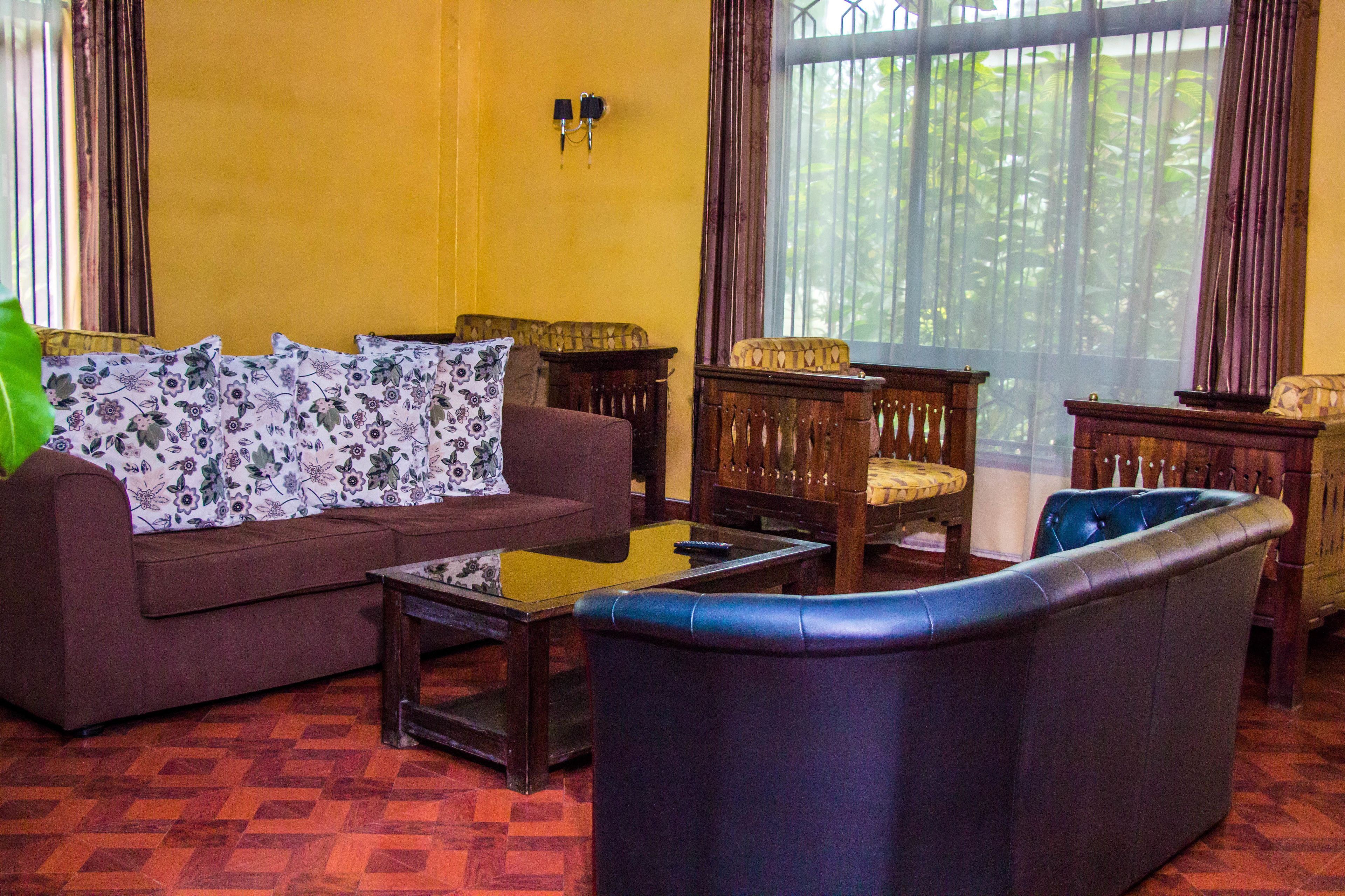 A living room with a brown sofa, a blue armchair, and a wooden coffee table.