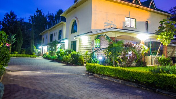 Une maison à deux étages avec une allée pavée et un jardin bien entretenu.