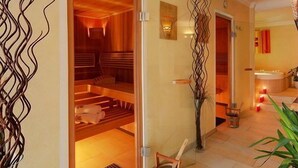 Een hotelhal met een warme inrichting, een zichtbare wellnessruimte door een open deur, en een receptie met een plant en kaarsen.