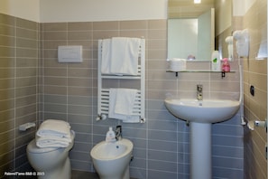 A bathroom with a toilet, bidet, and sink. There are towels on the wall and a mirror above the sink. - PalermiT'amo (Palermo)