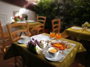 A breakfast setting with a table set for two, including croissants, orange juice, and coffee. - PalermiT'amo (Palermo)