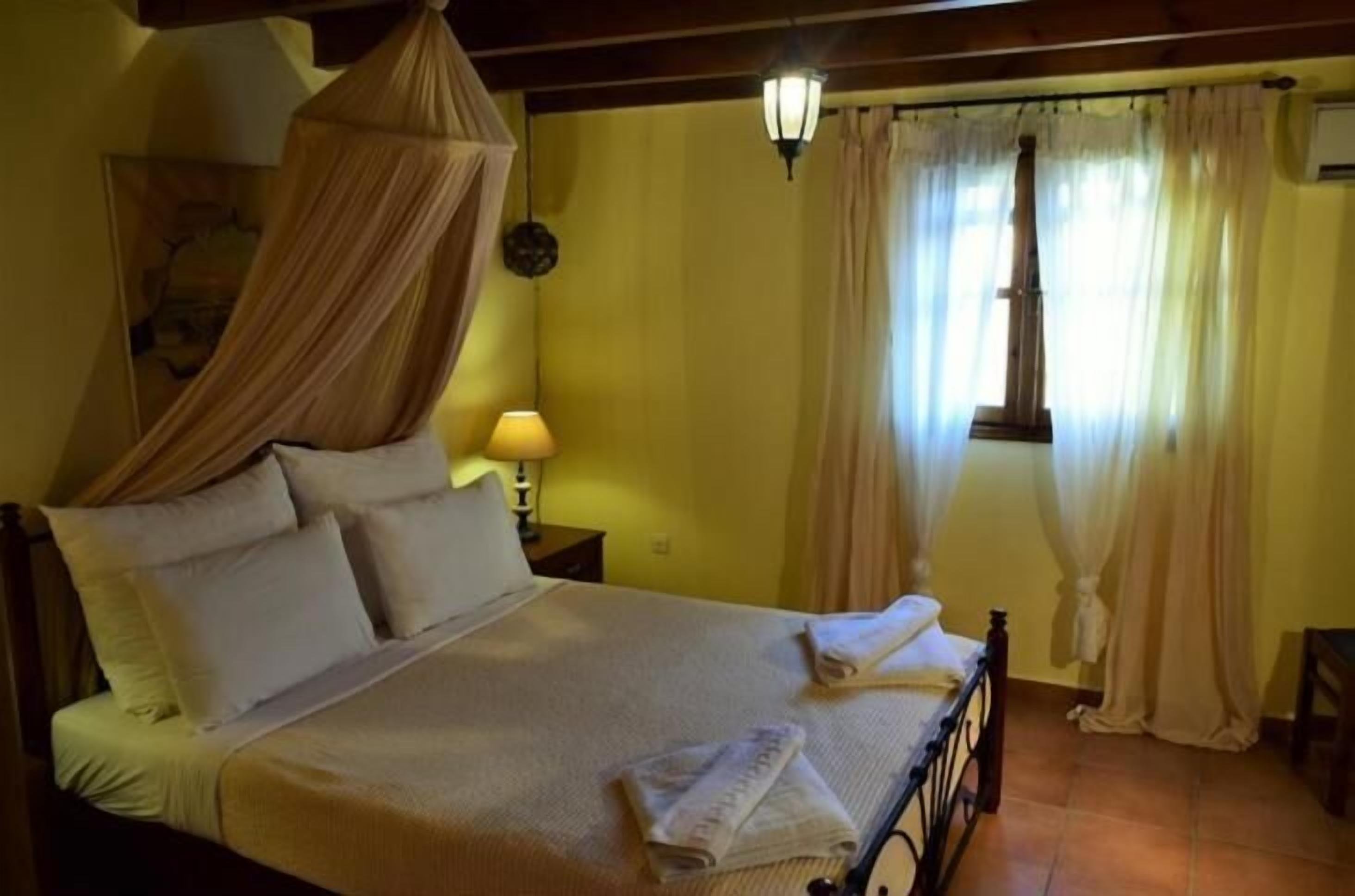 Un lit à baldaquin, une lampe de chevet et des rideaux.