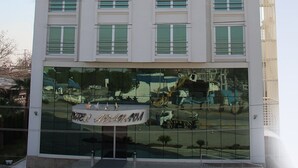 Een meerlaags hotelgebouw met een bordje met de tekst 'HOTEL ADANAVA' bovenaan.