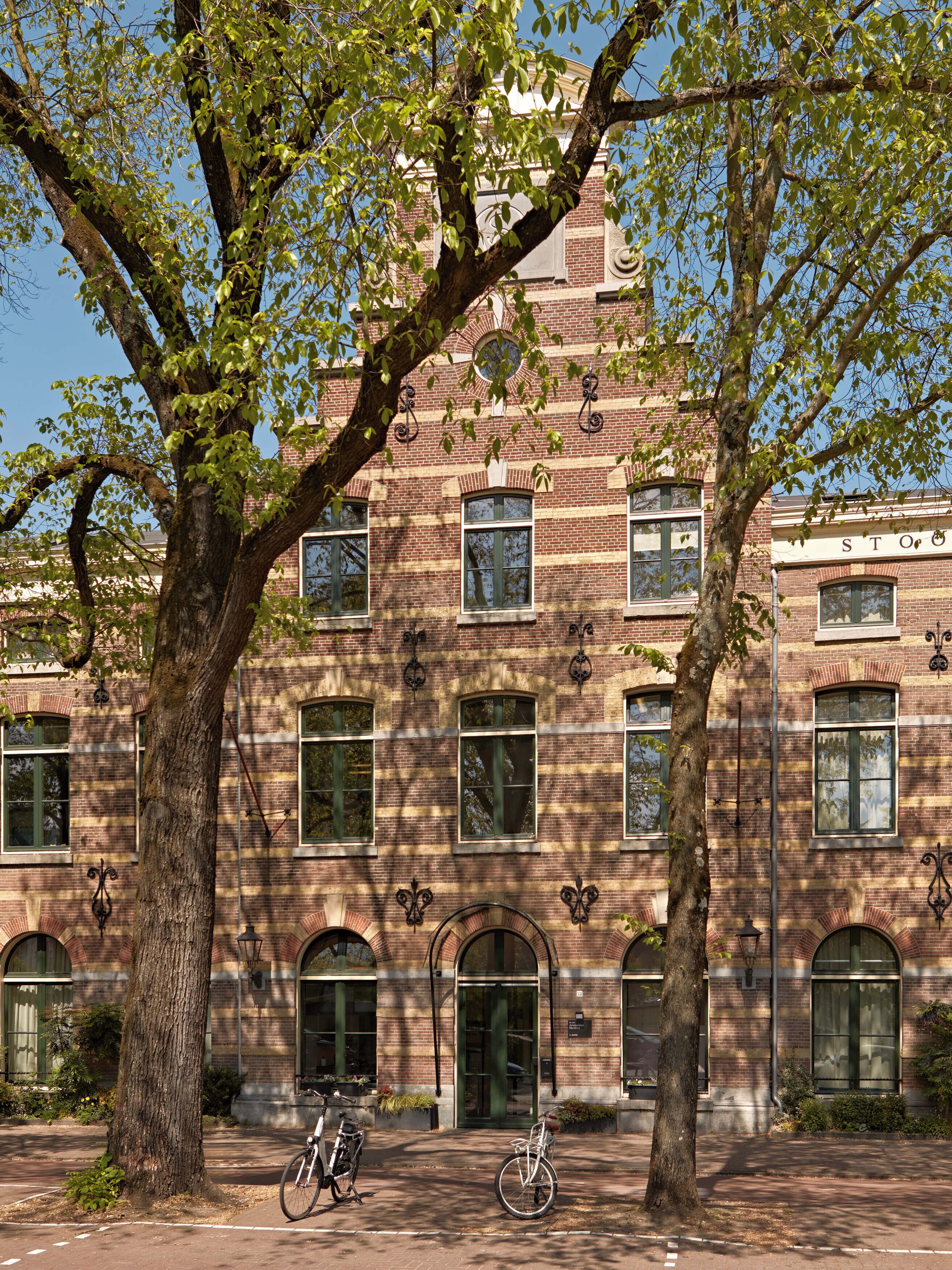 A brick building with arched windows and a central entrance.