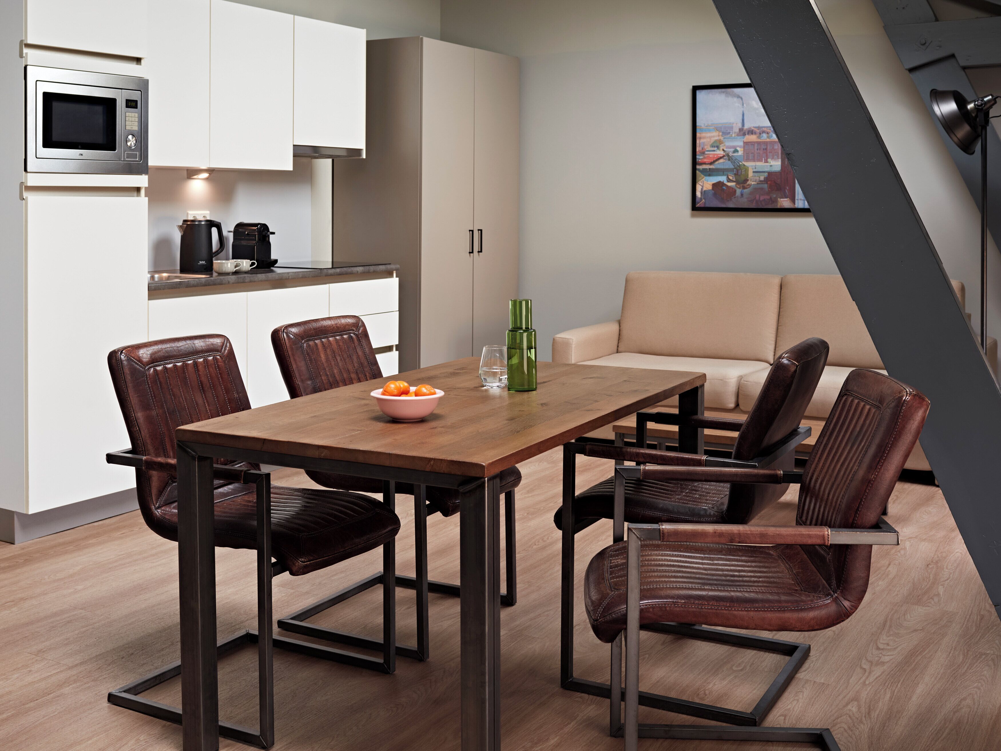 A modern kitchen with white cabinets, a built-in microwave, and a coffee maker.