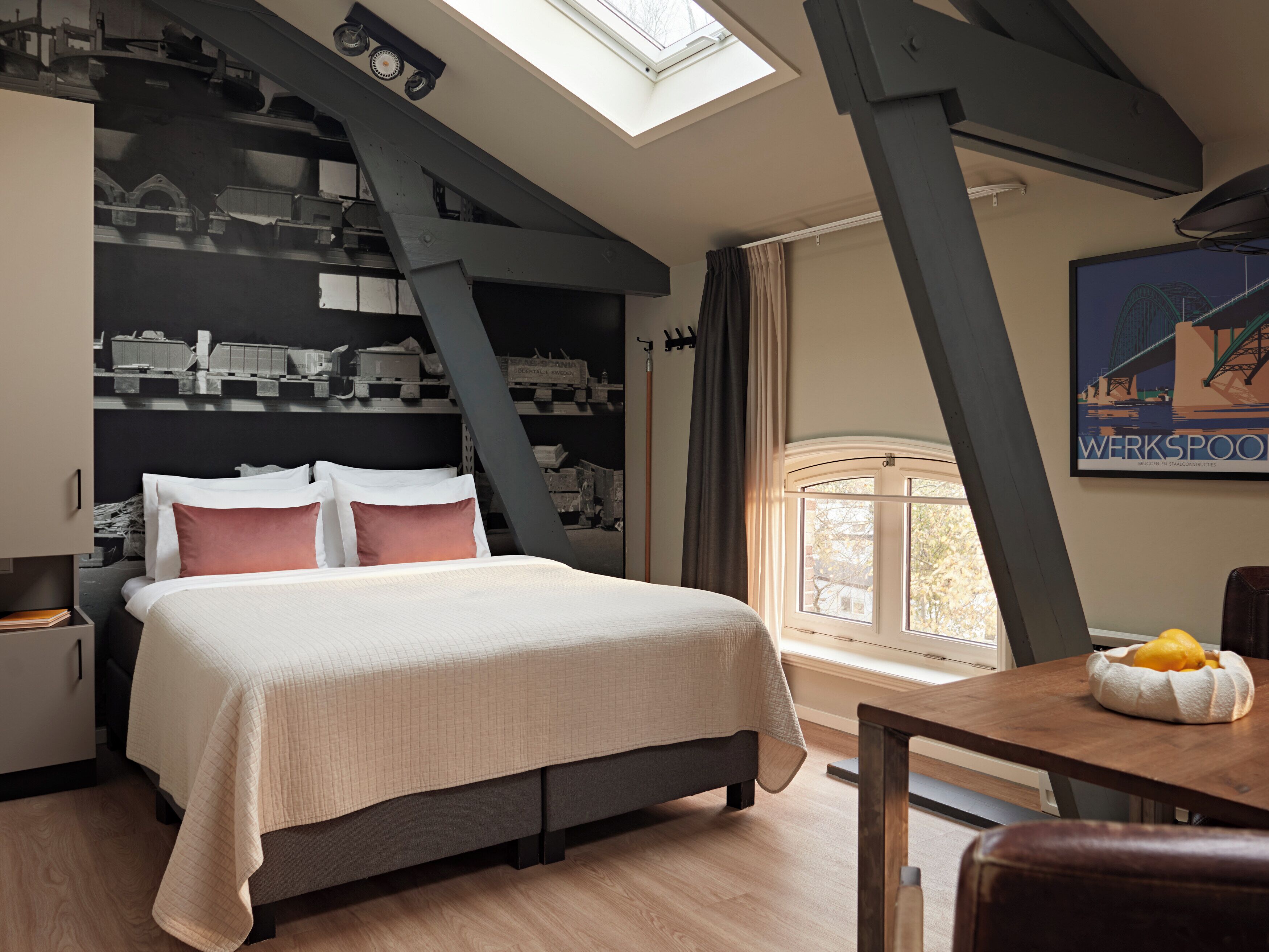 A bedroom with a bed, a desk, and a window.