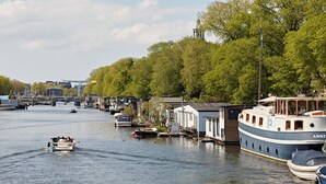 Ein Kanal mit Booten, einer Brücke und Gebäuden am Ufer.
