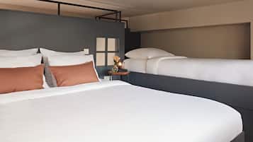 A hotel room with two beds, a nightstand, and a window.