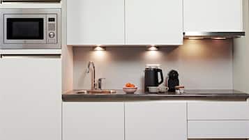 Een moderne keuken met een ingebouwde magnetron, een roestvrijstalen spoelbak en een waterkoker.