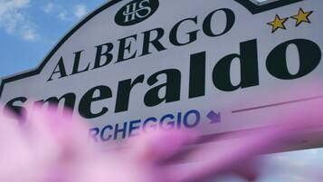 Een bord met de naam 'Albergo Smeraldo' en het woord 'RCHEGGIO' eronder.