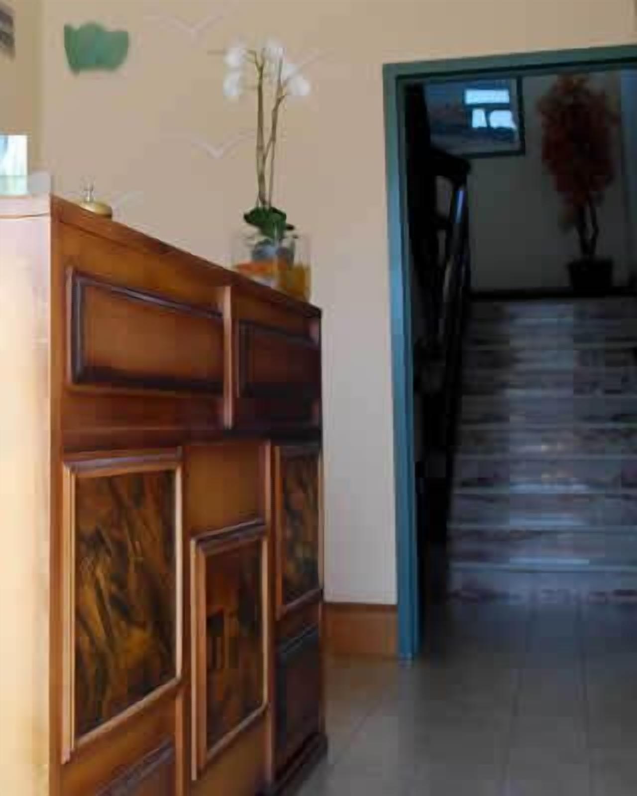 Ein Empfangsbereich mit einem Holztisch, einer Zimmerpflanze und einer Treppe, die zu einer anderen Etage führt.