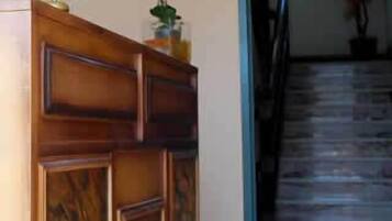 Ein Empfangsbereich mit einem Holztisch, einer Zimmerpflanze und einer Treppe, die zu einer anderen Etage führt.