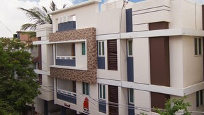 A multi-story residential building with a flat roof, balconies, and a visible sign for 'P&K Foundation'. - Phoenix Hospitality Services (Chennai)