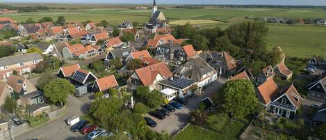 A village with traditional houses, a church, and a parking area.