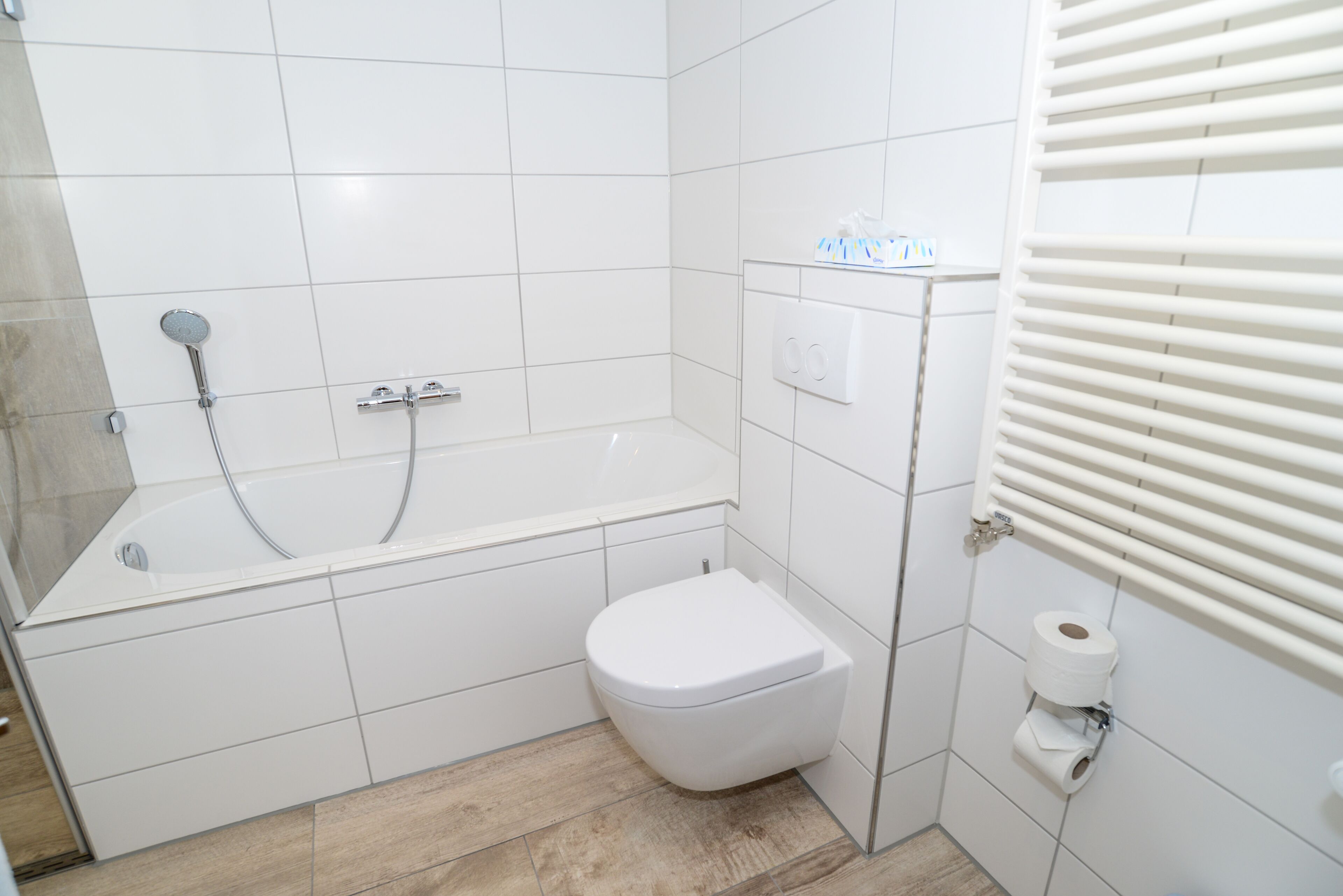 Un bagno con una vasca, un water e un portasciugamani.