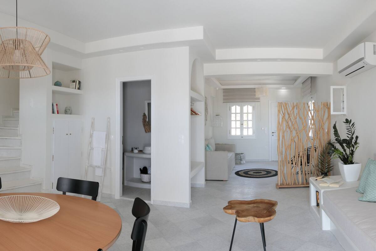 Un espace de vie moderne à aire ouverte comprenant un coin repas, une cuisine et un coin salon.