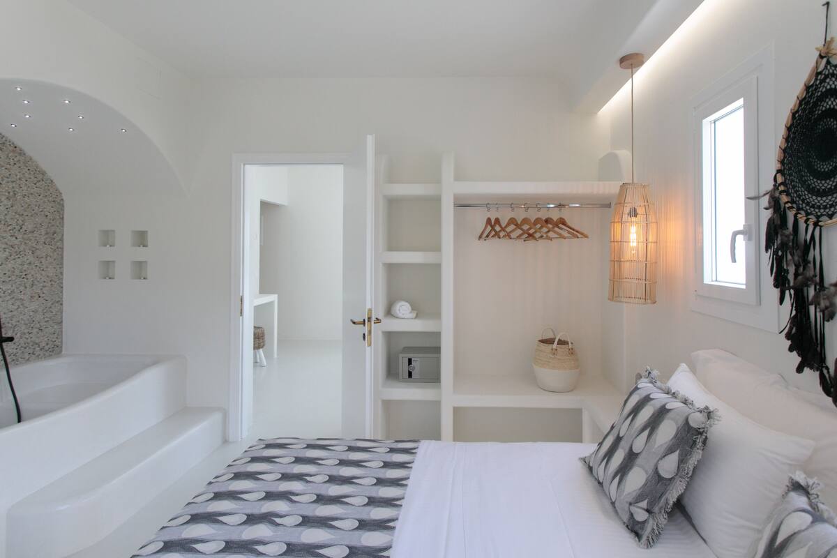 Une chambre à coucher moderne, avec un lit, une armoire intégrée, un luminaire suspendu et un élément décoratif mural.