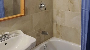 A bathroom with a bathtub, a shower, and a sink. - Niagara Inn (Niagara Falls)