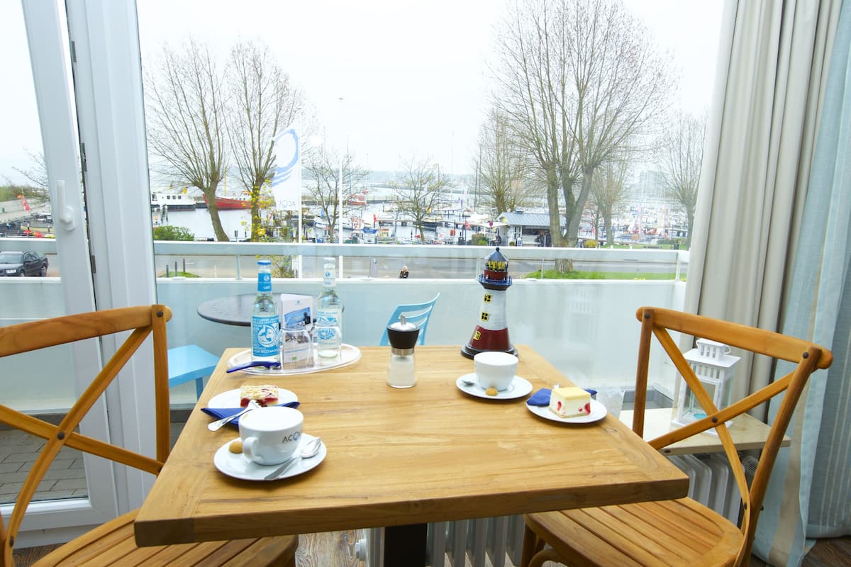 A wooden table set with plates, cups, and a small decorative lighthouse model.