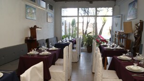 A dining area with tables set for a meal, chairs, and a potted plant. - Villa Mahefa (Antananarivo)