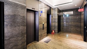 An elevator with a control panel, emergency stop button, and a sign indicating the floor. - CHECK inn Taipei Nanjing (Taipei)