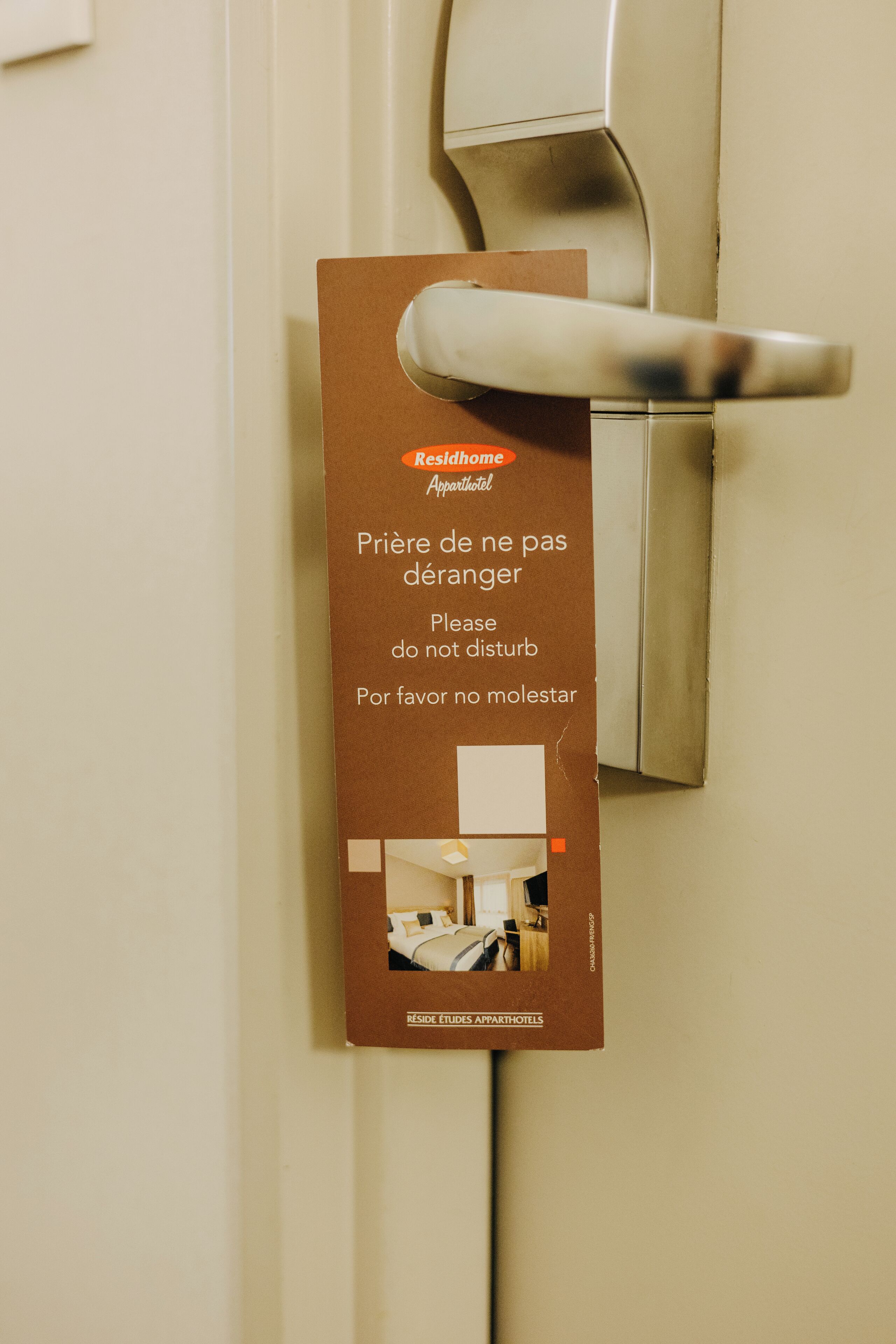 Un cartel en la puerta con instrucciones en francés e inglés solicitando a los huéspedes respetar el silencio.