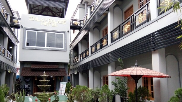 Inlay Palace Hotel with a courtyard featuring potted plants and outdoor seating. - Inlay Palace Hotel (Nyaungshwe)