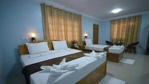 A hotel room with two beds, a desk, and a chair. - Inlay Palace Hotel (Nyaungshwe)