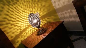 Une lampe posée sur une table en bois, avec un mur à texture en arrière-plan.