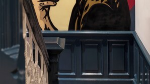 Una escalera con un mural de una persona sosteniendo un teléfono inteligente.
