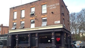 A brick building with the sign "EXMOUTH ARMS" and "Home of Burger Craft" on the facade. There are outdoor tables and benches in front. - Publove @ Exmouth Arms Euston (London)