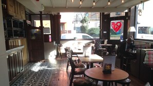 An interior with wooden flooring, a patterned rug, and a mix of wooden and upholstered furniture. - Publove @ Exmouth Arms Euston (London)