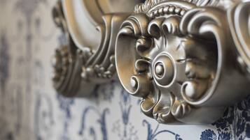 A close-up of a decorative metal rail with intricate scrollwork, likely part of a piece of furniture or a wall detail.