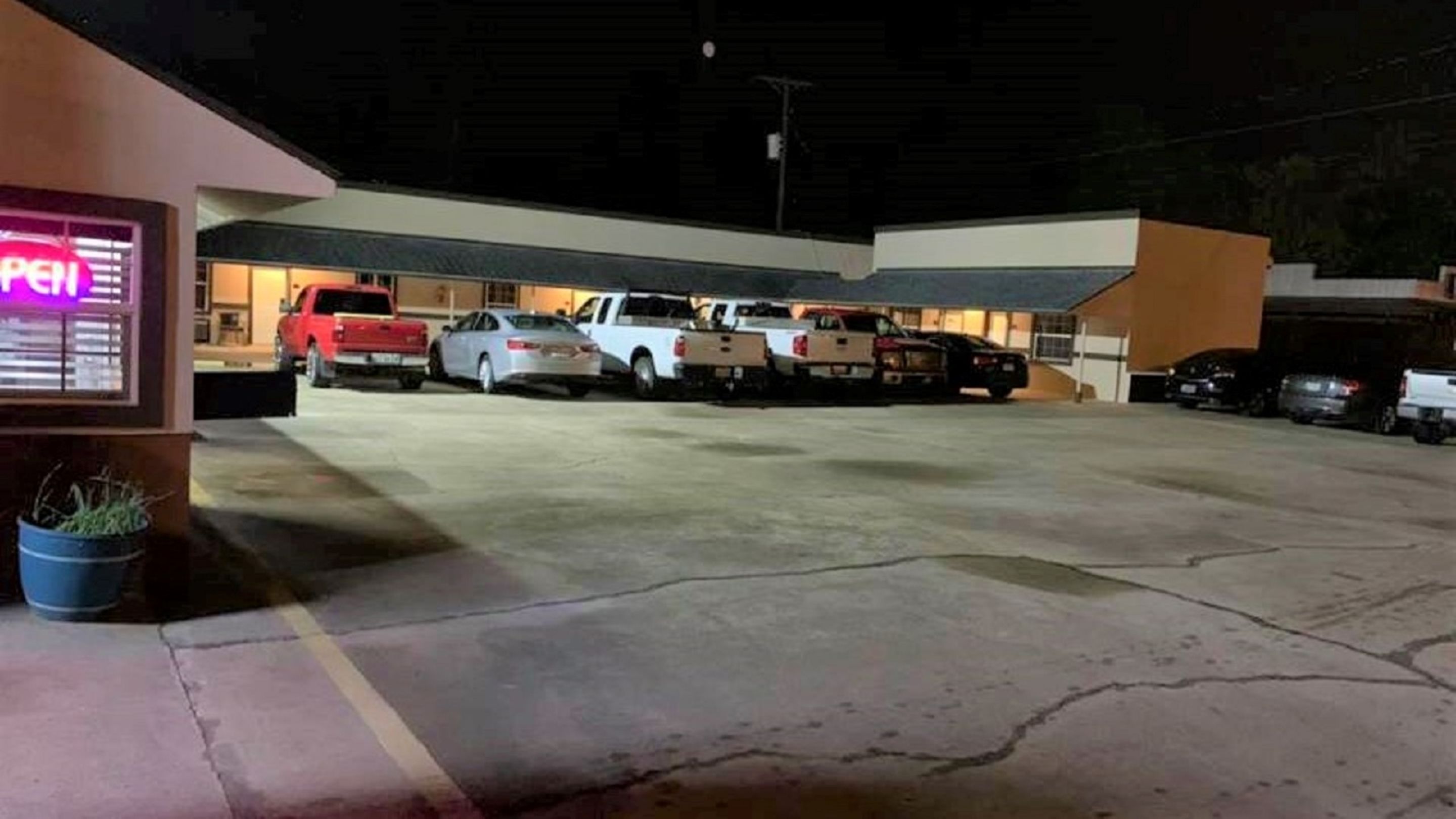 A parking garage with several vehicles, including trucks and cars, parked in an open area.