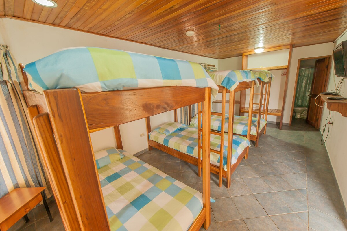 A room with bunk beds, wooden furniture, and tiled flooring.