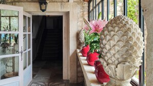 A reception area with a stone wall, a wooden ceiling, and a staircase leading to the upper floor. - Le Mas d'Aigret (Les Baux-de-Provence)