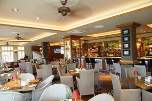 A hotel lobby with multiple seating areas, a bar, and a television screen. - The Busby Hotel (Glasgow)