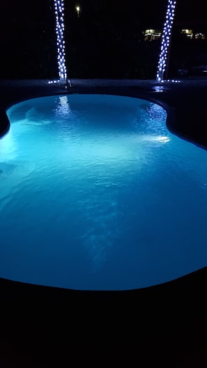 Piscina à noite com iluminação azul.