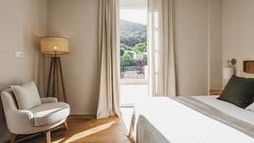 Un dormitorio con cama, una silla, una lámpara de pie y una ventana con cortinas.