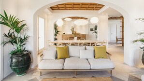 Een modern interieur met een bank, een eettafel en een boogvormige doorgang.