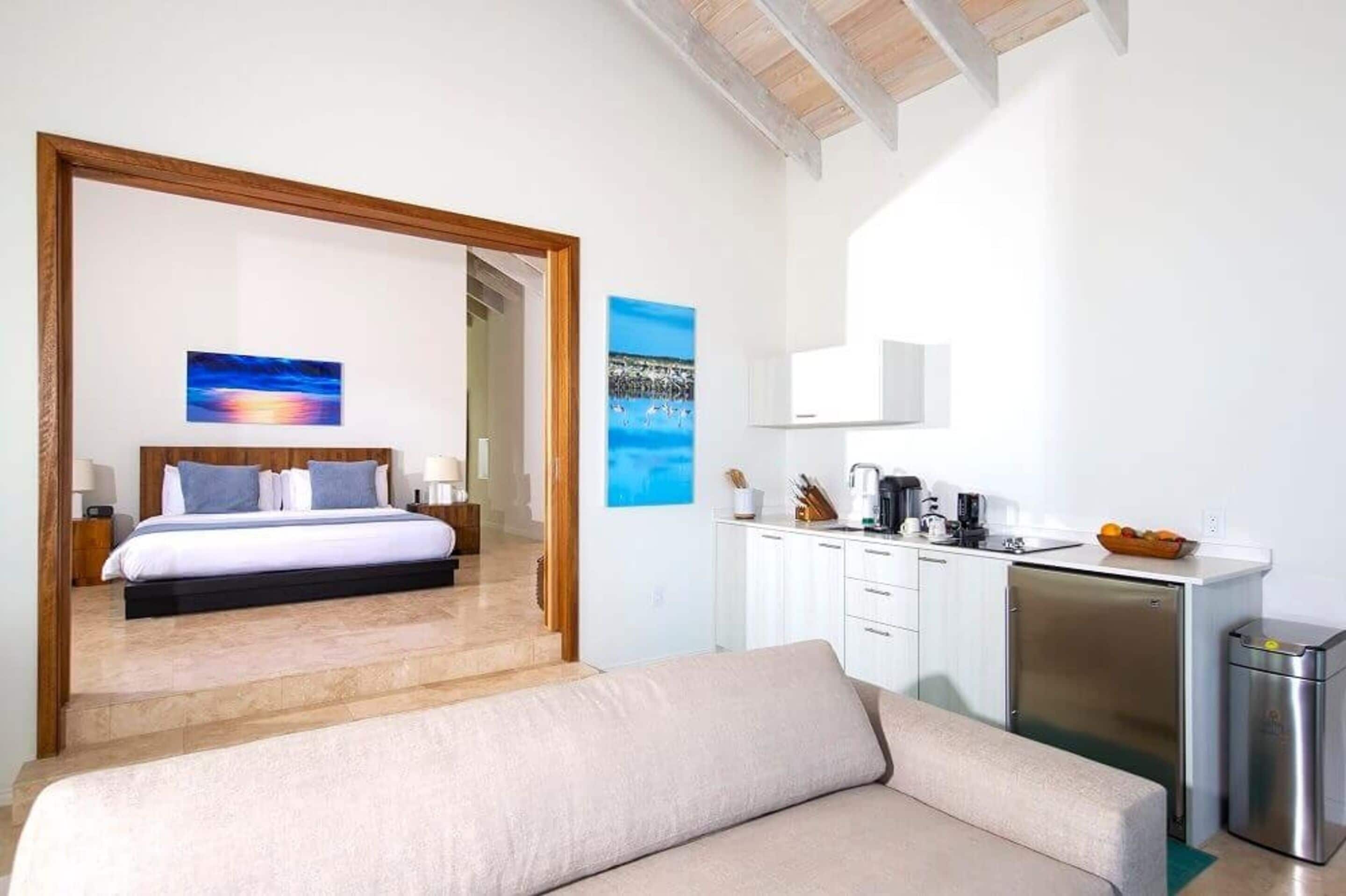 Une chambre d’hôtel moderne équipée d’un lit, d’un canapé, d’une kitchenette et d’une salle de bain.