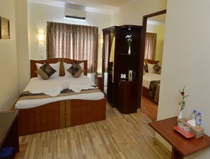 A hotel room with a wooden bed, a nightstand, a dresser, and a mirror. - Millennium Hotel (Yangon)