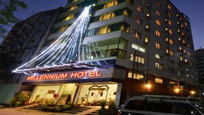 Un hotel con un letrero de neón, varios pisos y una entrada visible.