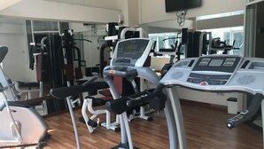 Un gimnasio con equipo de ejercicio variado, incluyendo cintas de correr y máquinas de pesas.