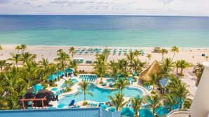 Un complexe hôtelier doté d’une piscine, d’une plage et offrant une vue sur l’océan.