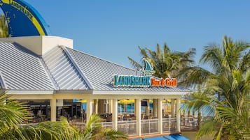 A beachfront restaurant named "Landshark Bar & Grill" with outdoor seating and palm trees.