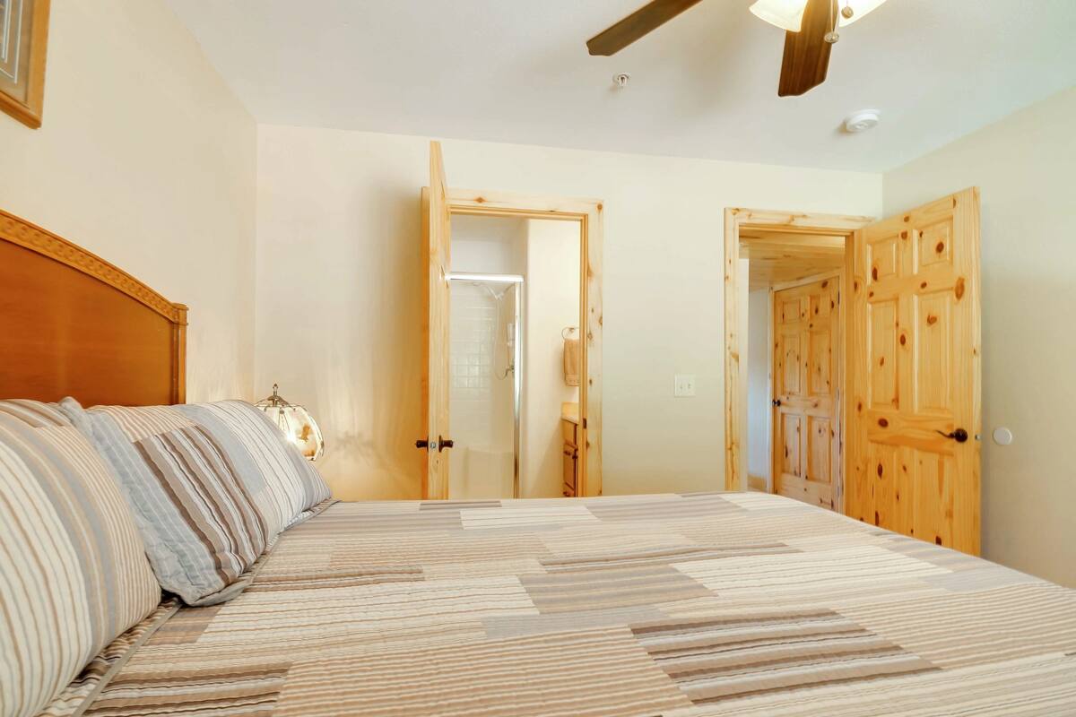 A bedroom with a bed, wooden doors, and a ceiling fan.