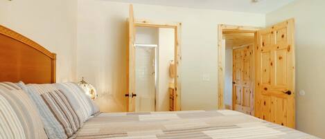A bedroom with a bed, wooden doors, and a ceiling fan.