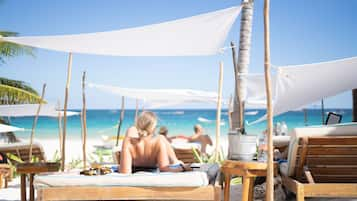 Plage, sable blanc, chaises longues, parasols