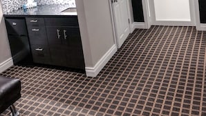 A compact kitchen with dark cabinets, a microwave, and a patterned floor. - Walkerton Inn Motel (Brockton)